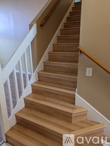 A wooden staircase with a white railing.