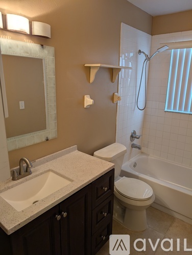 A bathroom with a sink, toilet, and bathtub.