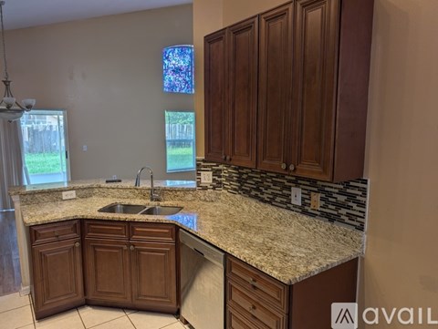 A kitchen with granite countertops and wooden cabinets.