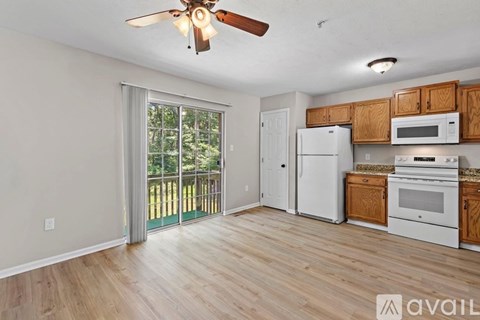 A kitchen with wooden cabinets and a white fridge is shown.