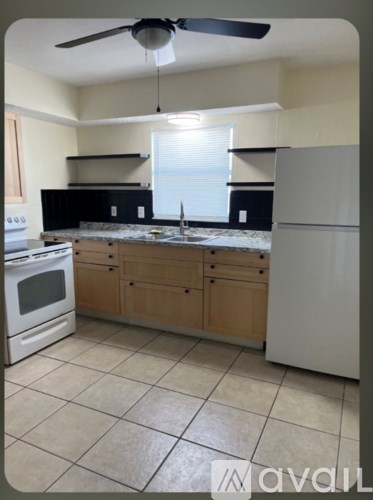 A kitchen with a white refrigerator, white oven, and wooden cabinets.