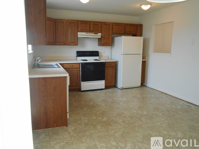 A kitchen with wooden cabinets and a white refrigerator.