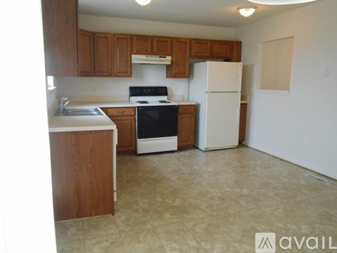 A kitchen with wooden cabinets and a white refrigerator.