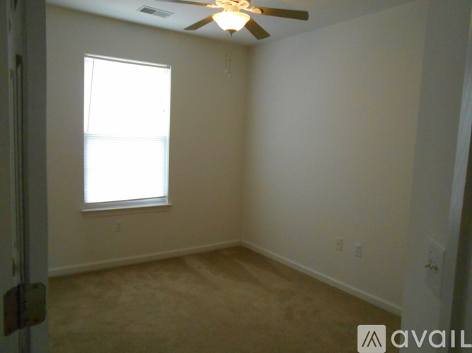 A room with a ceiling fan and a window.