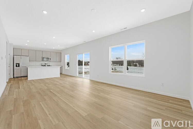 A spacious room with wooden flooring and white walls.