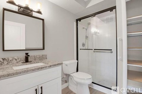 A bathroom with a toilet, sink, and shower.