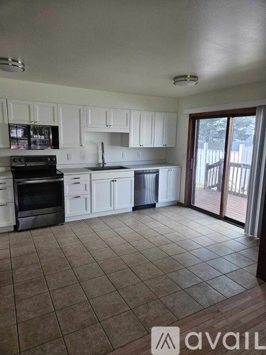 A kitchen with white cabinets and appliances, a microwave, and a dishwasher.