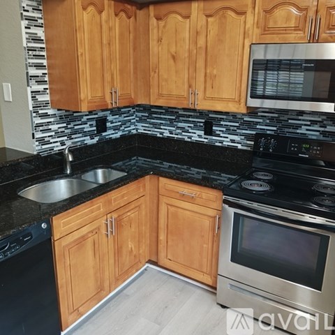 A kitchen with wooden cabinets and a black countertop.