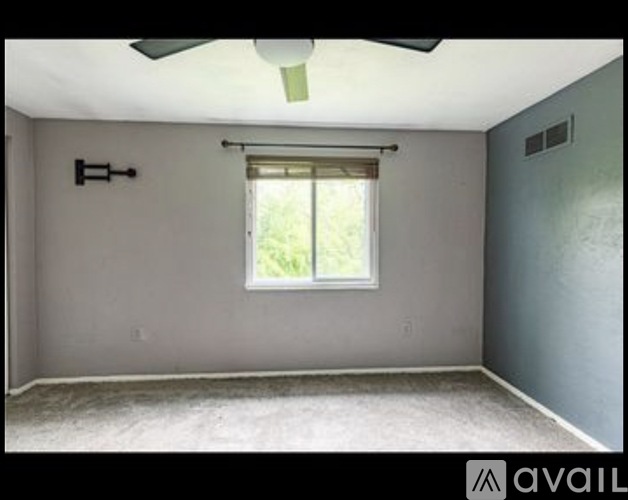 A room with a window and a ceiling fan.