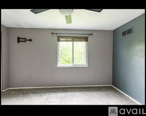A room with a window and a ceiling fan.
