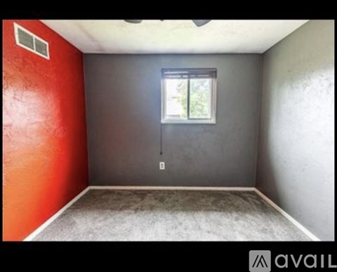 A room with a window and a light switch on the wall.