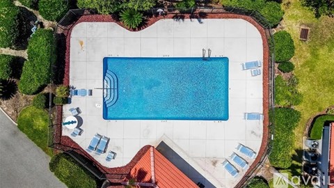 An aerial view of a swimming pool surrounded by a red tile border.