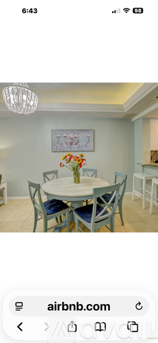 A dining room with a white table and blue chairs.