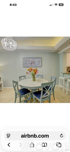 A dining room with a white table and blue chairs.