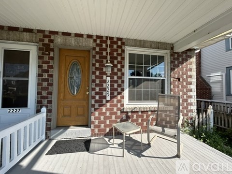 A house with a brown door and a white fence.