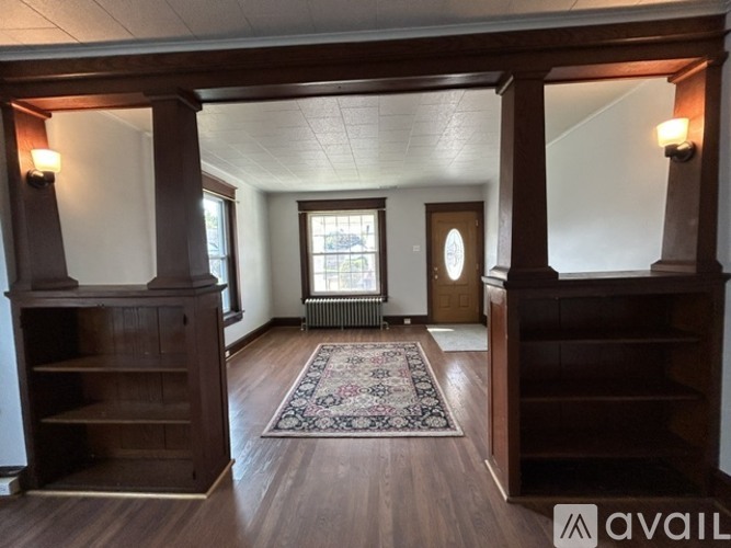 A room with wooden floors and a rug in the middle.