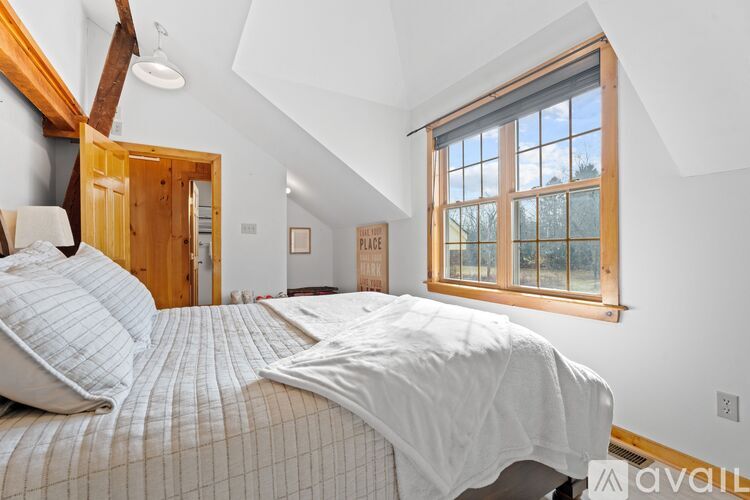 A bedroom with a large bed and a window.