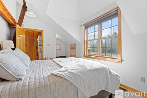 A bedroom with a large bed and a window.