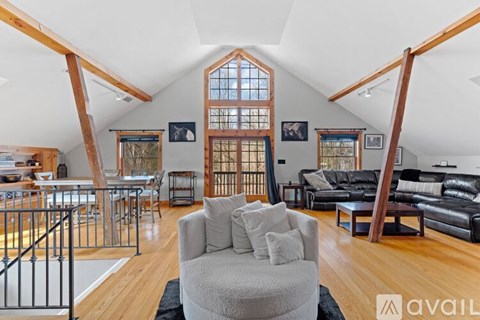 A spacious living room with a large grey couch and a wooden floor.