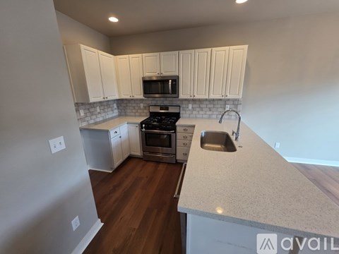 A kitchen with white cabinets and a black stove top oven.
