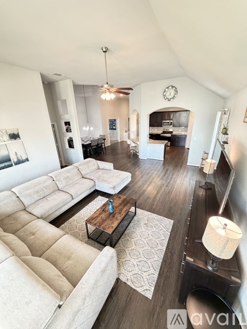 A living room with a large sectional sofa and a coffee table in the center.