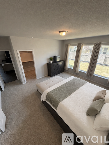 A bedroom with a large bed and a television.