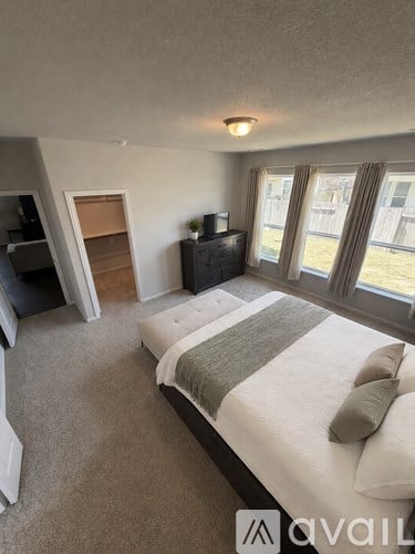 A bedroom with a large bed and a television.