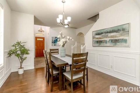 A dining room with a wooden table and chairs.