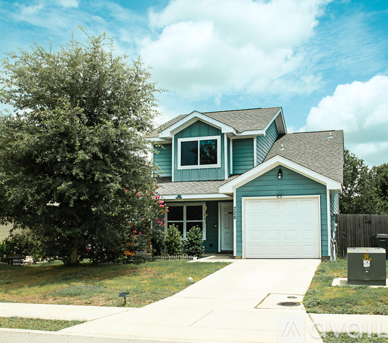 A blue house with a white garage door and a grey roof.