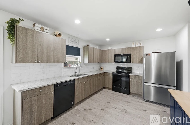 A kitchen with wooden cabinets and a stainless steel refrigerator.