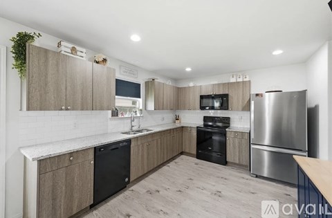 A kitchen with wooden cabinets and a stainless steel refrigerator.
