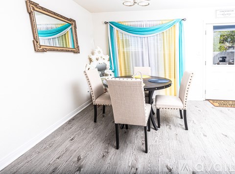A dining room with a table and chairs.