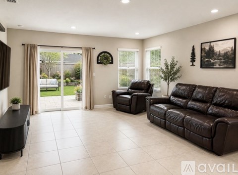 A living room with a brown leather couch and a black coffee table.