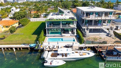 A large house with a pool and boats in front.