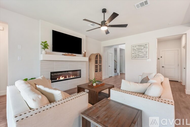 A living room with a fireplace and a television on the wall.
