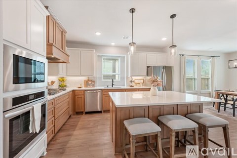 A modern kitchen with wooden cabinets and stainless steel appliances.
