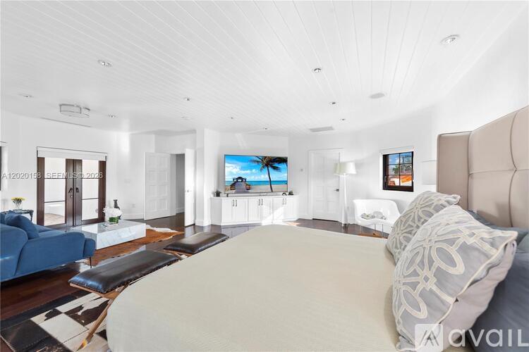 A modern bedroom with a large bed and a flat screen TV.