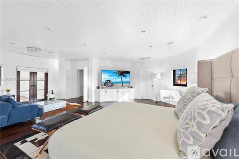A modern bedroom with a large bed and a flat screen TV.