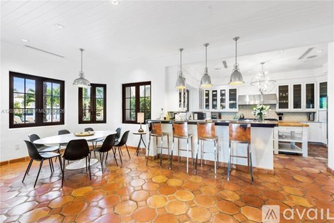 A kitchen with a table and chairs in the middle of the room.