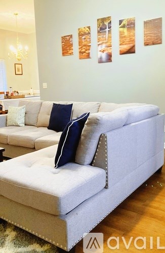 A white couch with blue pillows in a living room.