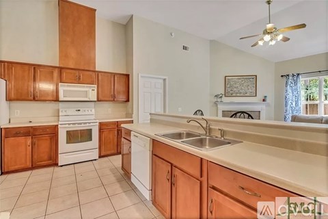 A kitchen with white appliances and wooden cabinets.