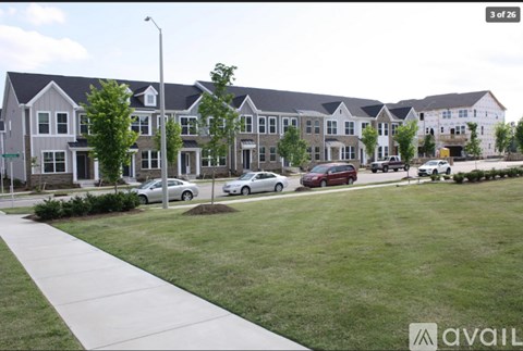 A row of houses with cars parked in front.