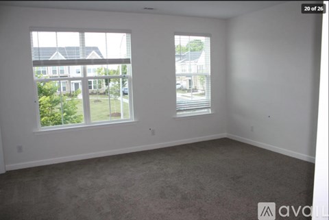 A room with two windows overlooking a street.
