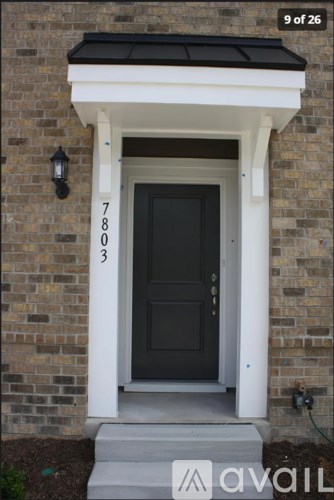 A black door is on the right side of a white frame.