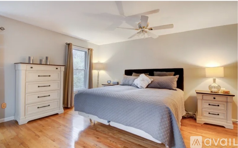 A bedroom with a large bed and a dresser.