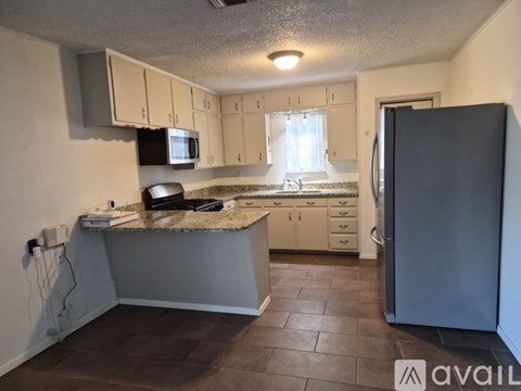 A kitchen with a refrigerator on the right side.