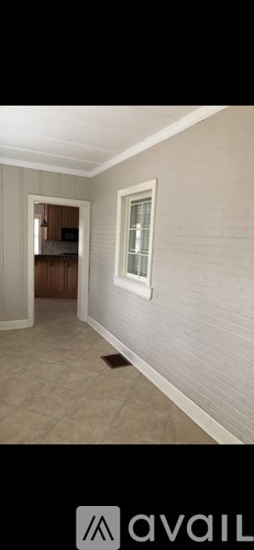 A room with a white wall and a window.
