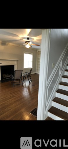 A living room with a staircase leading to the second floor.