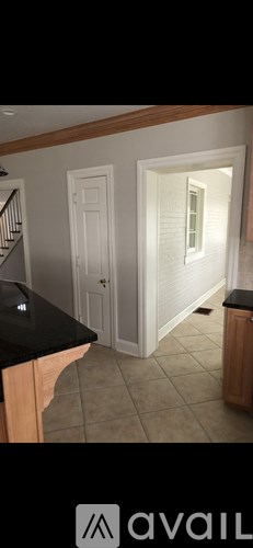 A kitchen with a black counter top and white walls.