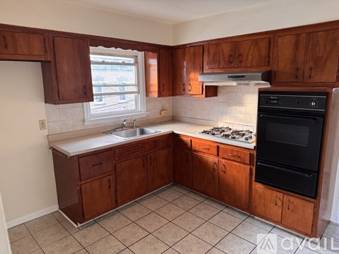 A kitchen with wooden cabinets and a black oven.